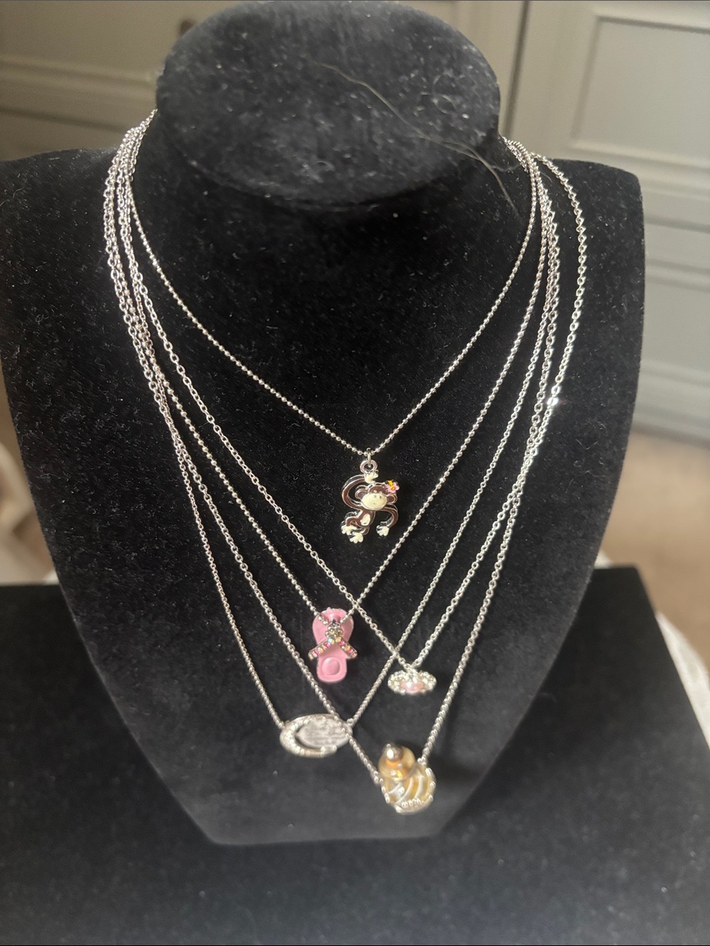 5 silvertone novelty necklaces with delicate chains.